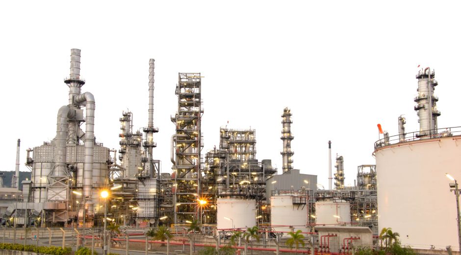 Industrial refinery complex with storage tanks and pipelines.